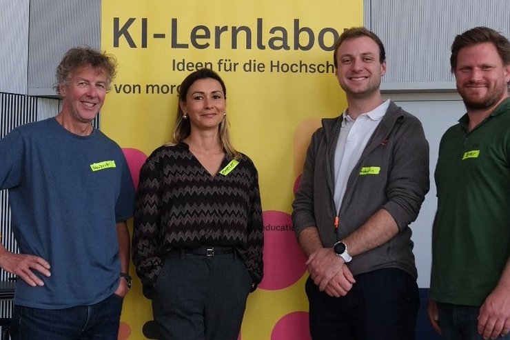 Personen vor einem Werbebanner des KI Labors