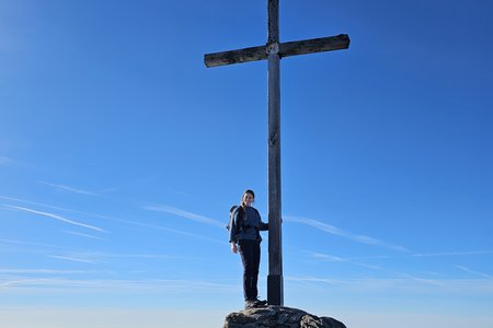 Eine Kemptener Mitarbeiterin am Gipfelkreuz des Großen Arbers. 