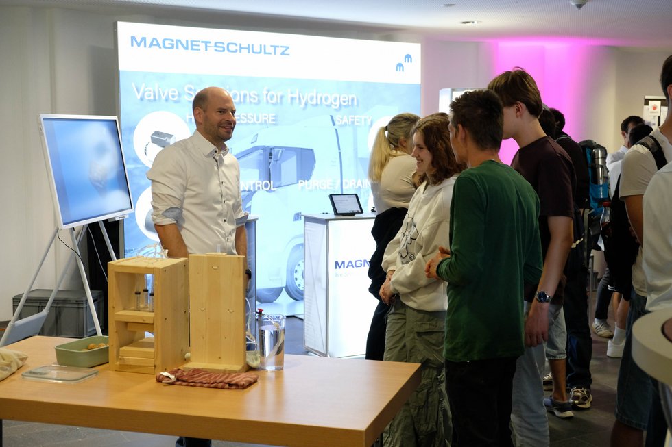 Personen vor einem Messestand 