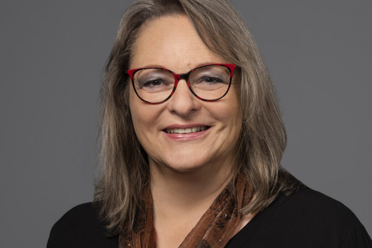 Michaela Tober Eine Frau mit langen grauen Haaren und Brille lächelt in die Kamera