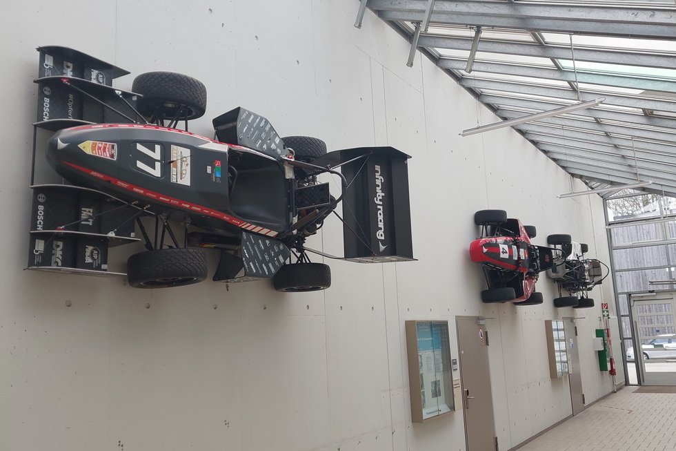 Rennwägen hängen im Gang der Maschinenhalle an der Wand