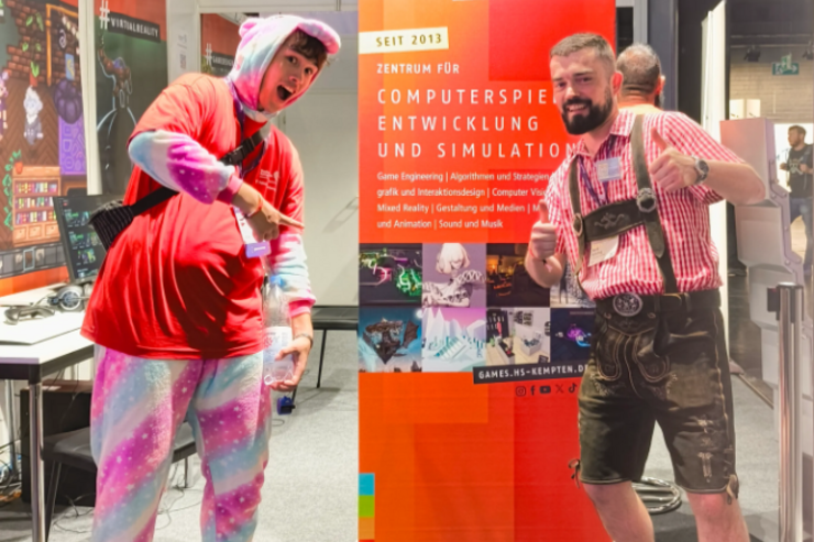 Messepersonal: ein Studierender im Einhornkostüm und Prof. Dr. Bühling in Lederhose posieren vor dem Rollup des Zentrums für Computerspieleentwicklung und Simulation