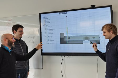 v.l.n.r. Projektleiter Prof. Dr. Frank Schirmeier, Projektmitarbeiter Maximilian Rost und Dr. Fabio Lischka vor einem Bildschirm, der eine technische Zeichnung zeigt. 