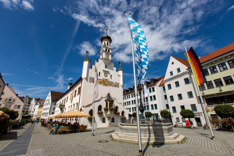 Das weiß verputzte Rathaus in der Kemptner Altstadt vor blauem Himmel