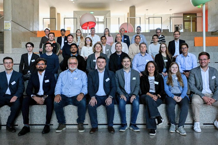 Gruppenfoto der Teilnehmenden des RESURRECTION-Kick-offs an der Hochschule Kempten. Mehr als 30 Fachleute aus Wissenschaft und Industrie sitzen und stehen gemeinsam auf einer Treppe im Hochschulgebäude.