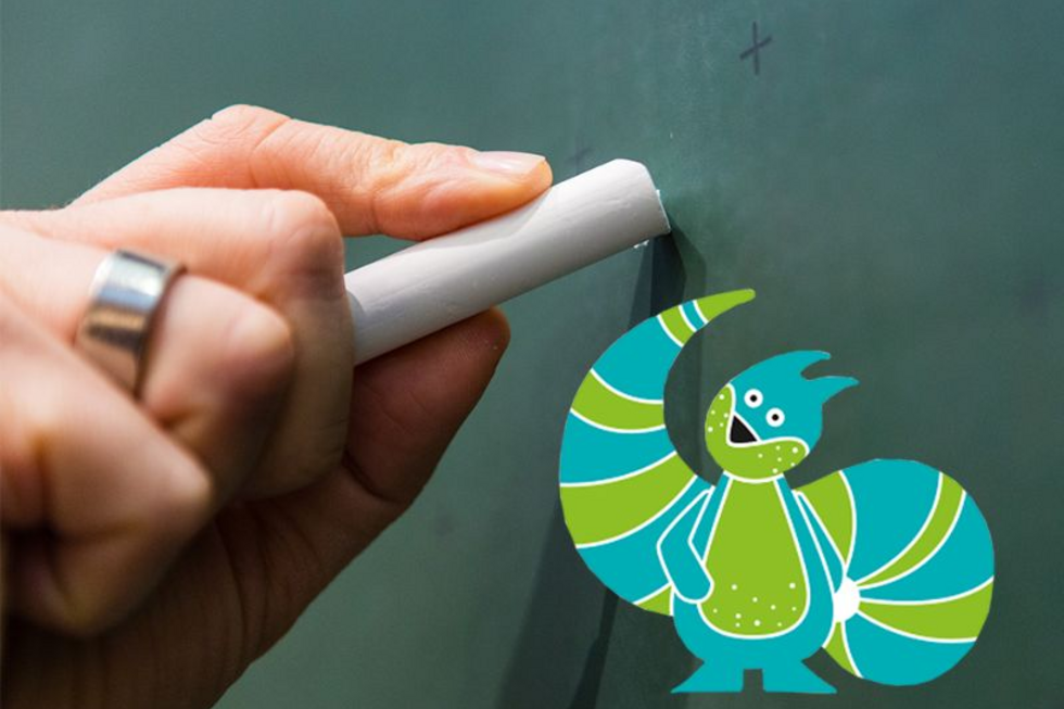 Hand schreibt mit Kreide auf Tafel