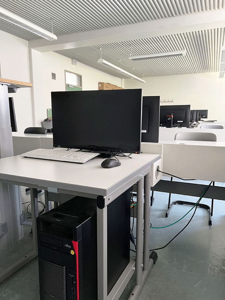 Dozenten-Arbeitsplatz im Labor für Game Engineering, im Hintergrund die Sitzreihen für die Studierenden.