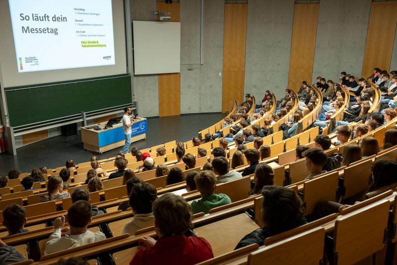 Gut besuchter Hörsaal der Hochschule Kempten während einer Informationsveranstaltung zur Allgäuer Hochschulmesse. Zahlreiche Teilnehmende verfolgen einen Vortrag zum Ablauf des Messetags.