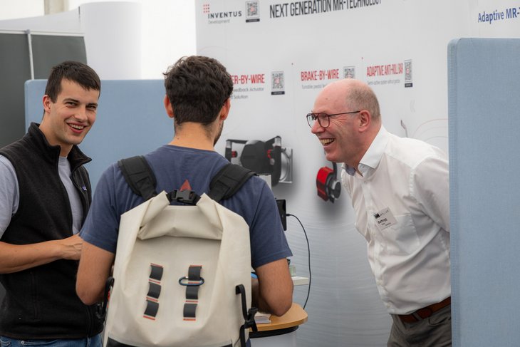 Personen vor einem Messestand 