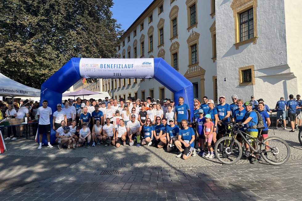 Gruppenfoto des Teams „Gesicht zeigen für Vielfalt“ beim Allgäuer Benefizlauf 2026 mit Mitarbeitenden der Hochschule Kempten und der Stadt Kempten vor dem Startbogen.