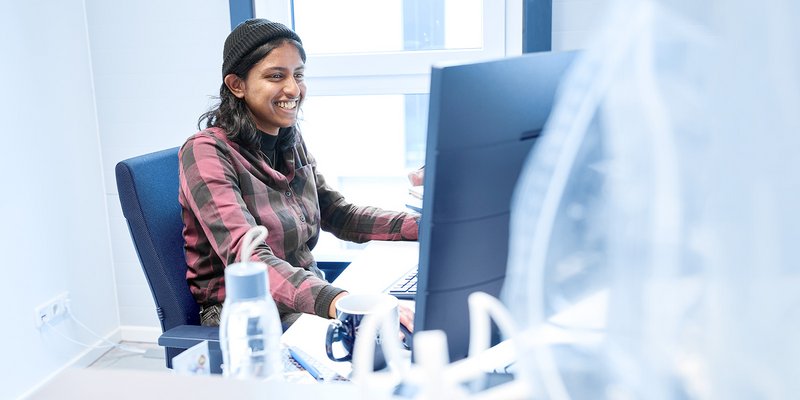 Junge Frau arbeitet an einem großen Bildschirmarbeitsplatz in einem modernen Büro der Hochschule Kempten