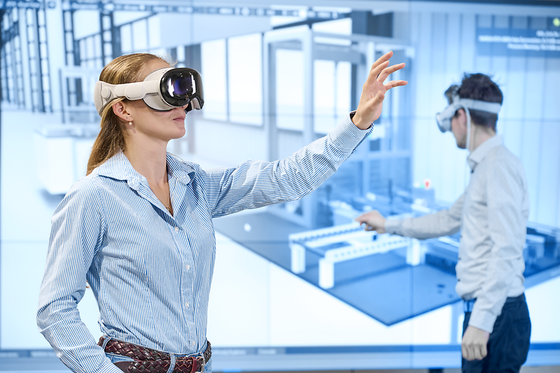 Zwei Mitarbeiter des IPI visualisieren mittels VR-Brille eine simulierte Produktionsstraße