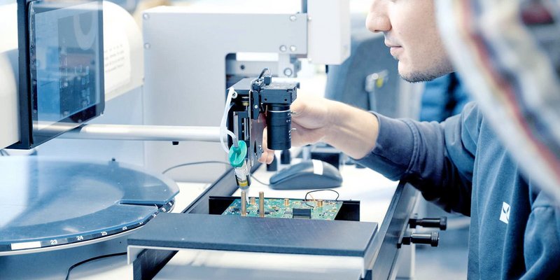 Nahaufnahme eines technischen Arbeitsplatzes mit Messgeräten und Leiterplatten