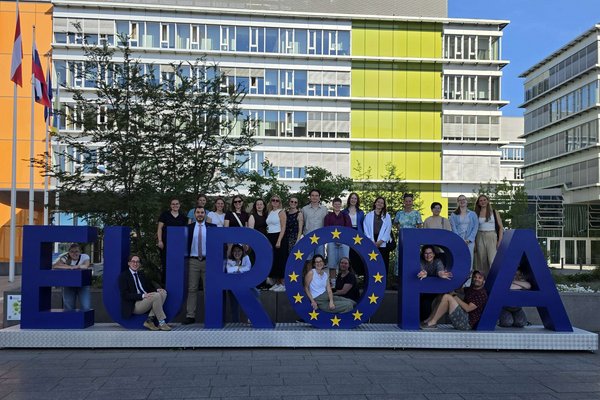 Eine Gruppe Menschen steht um eine Skulptur in Form des Wortes Europa herum.