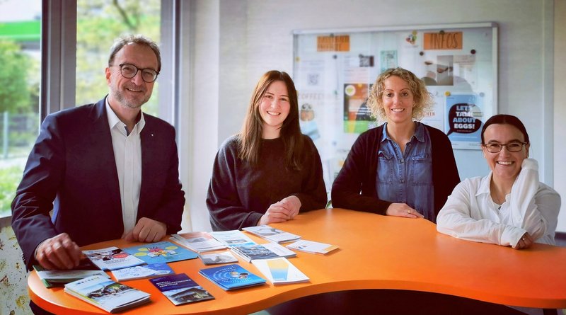 Das Team der regionalen Fachstelle für Demenz und Pflege Schwaben zeigt sich gemeinsam vor einem orangenen Tresen in den Räumen am Standort in der Rottachstraße in Kempten.