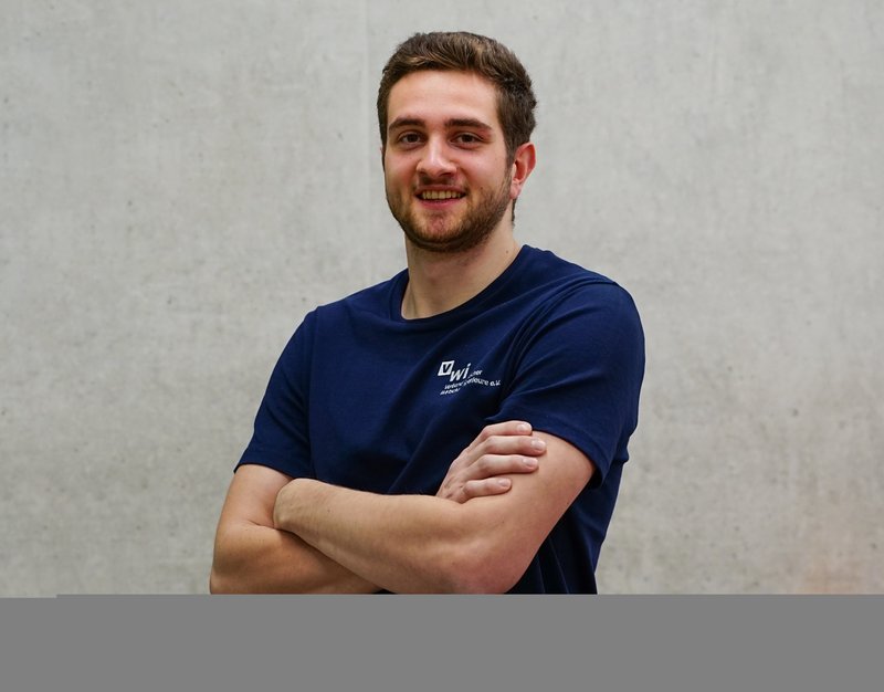 Student Lukas Nieß steht mit verschränkten Armen vor einer Betonwand