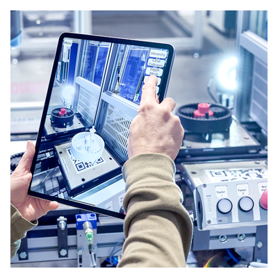 Eine Person fotografiert eine Maschine mit einem Tablet
