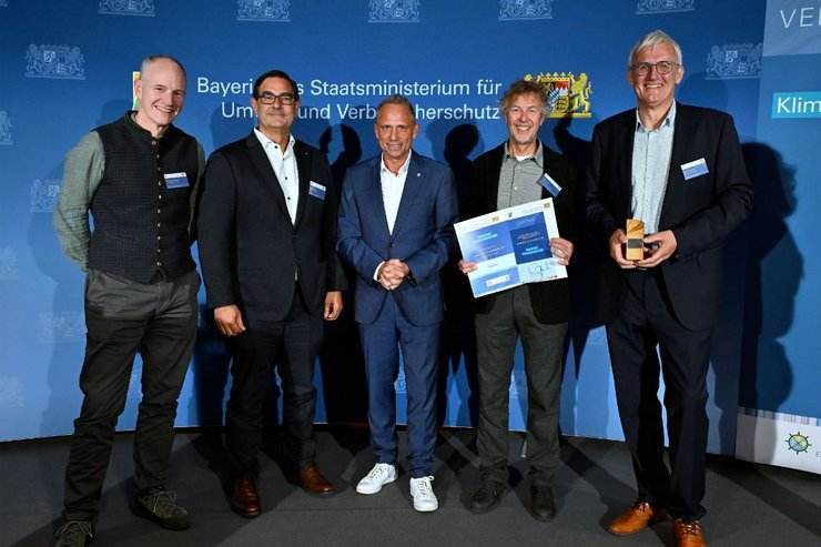 ayerns Umwelt- und Verbraucherschutzminister Thorsten Glauber überreicht den Bayerischen Klimaschutzpreis 2026 an das Team von power2move. Von links: Prof. Dr. Martin Steyer, Martin Haslsch, Thorsten Glauber, Norbert Grotz, Helmut Berchtold. [Foto: Bayerisches Staatsministerium für Umwelt und Verbraucherschutz]