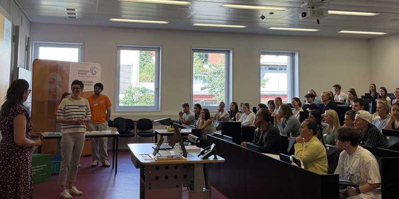 Die Teilnehmenden des Campustags der Fakultät Soziales und Gesundheit werden im gut gefüllten Hörsaal freundlich begrüßt 