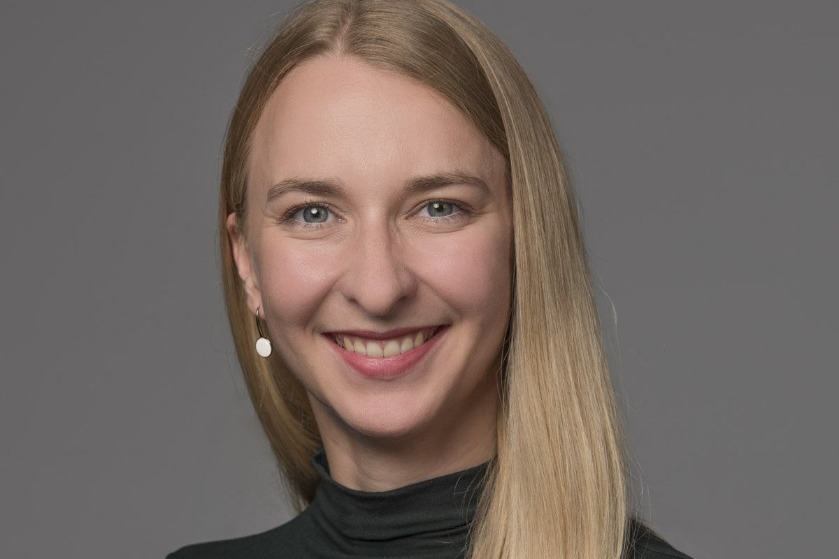 Eine Frau mit langen blonden Haaren lächelt in die Kamera