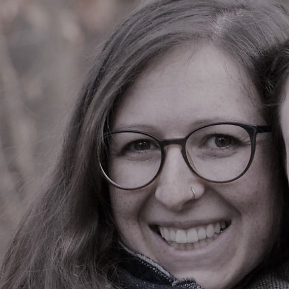 Schwarzweiss Portrait einer Frau mit langen Haaren und Brille mit Nasenpiercing