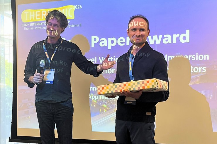 Johann Renner (rechts) vom EI-Lab der Hochschule Kempten nimmt den Best Paper Award der THERMINIC 2026 von Programme Chair Bernhard Wunderle entgegen.