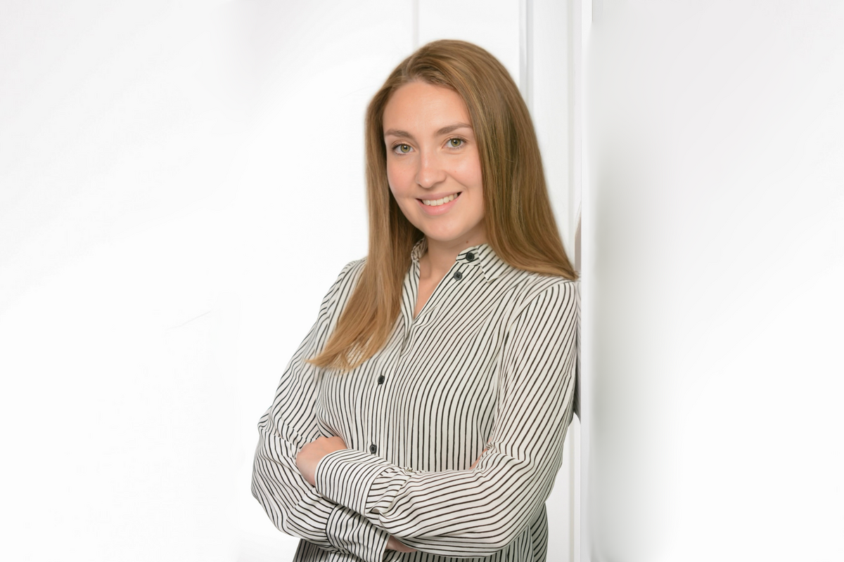 Ines Janzen Eine Frau mit langen braunen Haaren lächelt in die Kamera