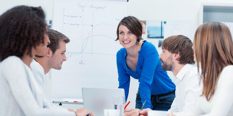 Gruppe junger Menschen bei einer Projektbesprechung vor einem Flipchart