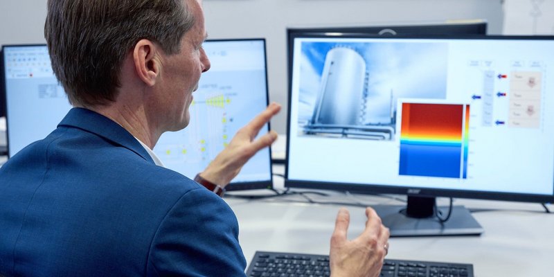 Ein Mann arbeitet am Computer mit einer technischen Simulationssoftware.