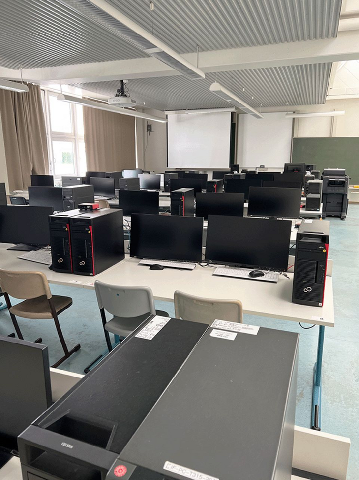 Zahlreiche Bildschirme und Computer in den Sitzreihen des Labors