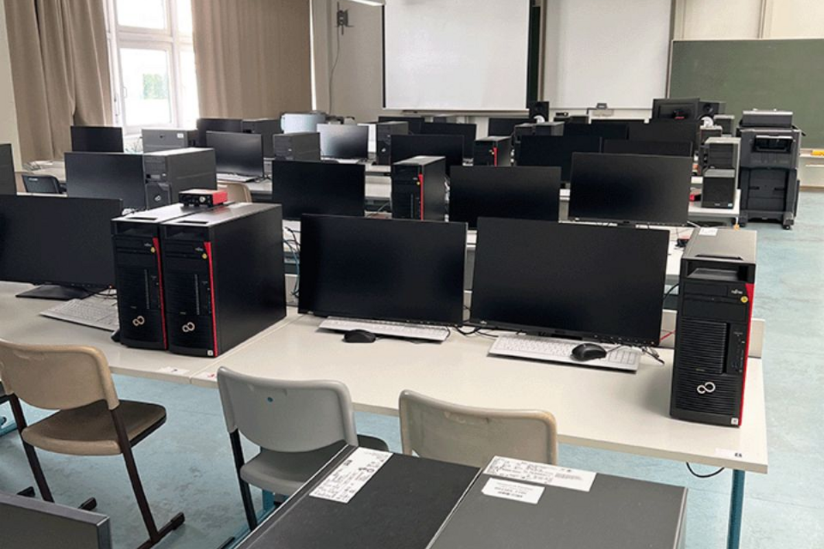 Zahlreiche Bildschirme und Computer in den Sitzreihen des Labors