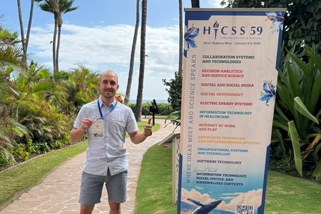 Doktorand Pius Finkel neben einem Konferenzrollup