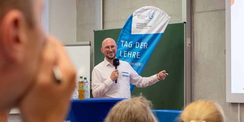 Eine Person präsentiert etwas vor einer Leinwand 