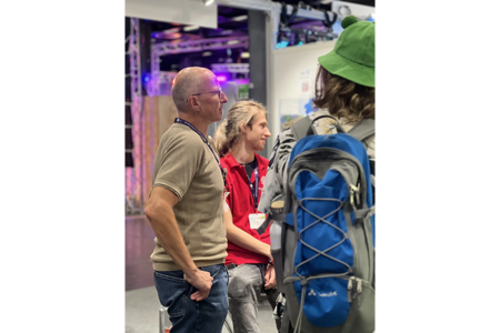 Prof. Dr. Dreier ist mit Studierenden und Besuchern am Messestand in ein Gespräch vertieft.