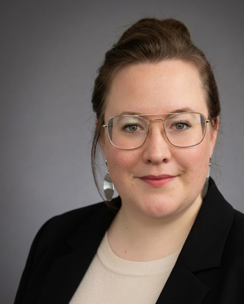 Eine Frau mit braunen Haaren und einer Brille