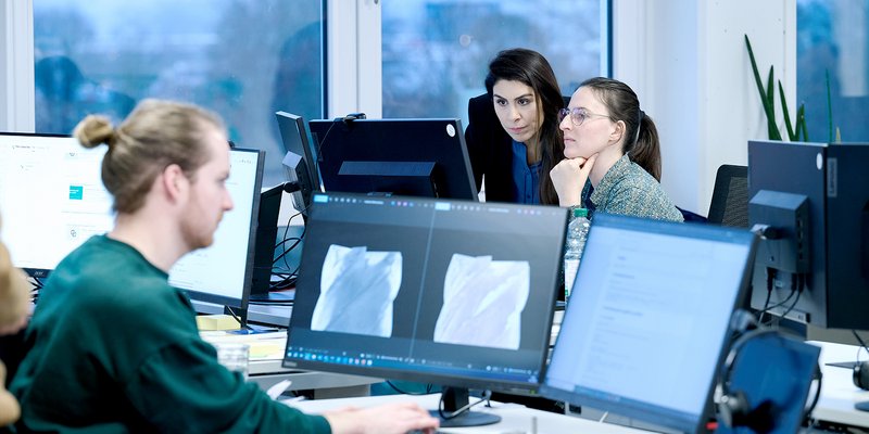 Zwei Frauen arbeiten gemeinsam an einem Computerarbeitsplatz im modernen Büro der Hochschule Kempten und besprechen digitale Inhalte